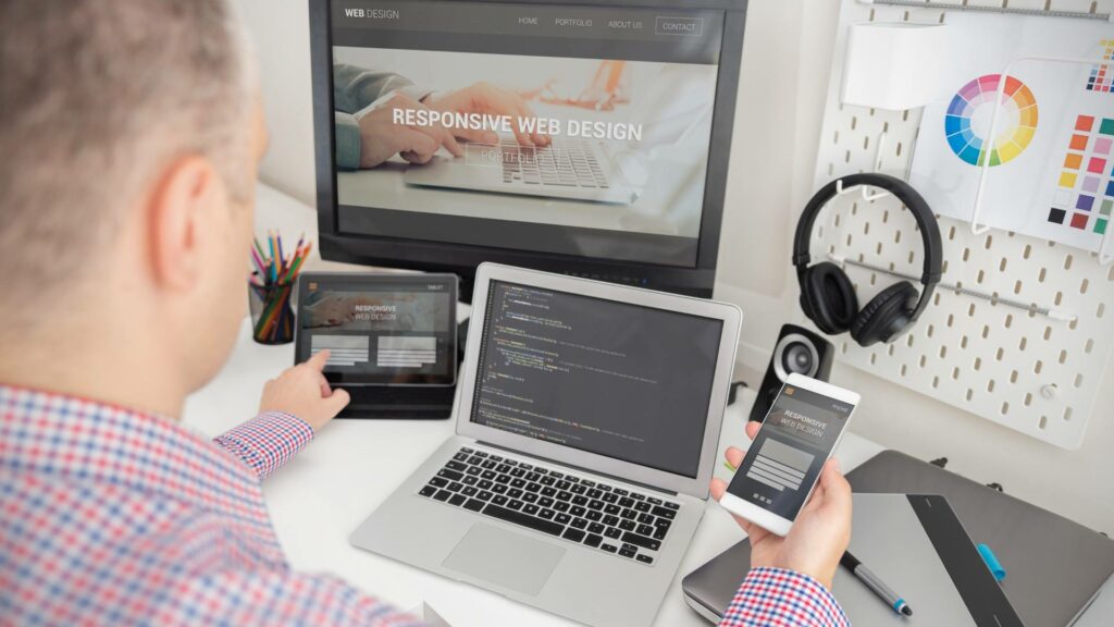 A desktop, laptop, tablet, and phone are displayed with the same web design, which has white text that says Responsive Web Design.