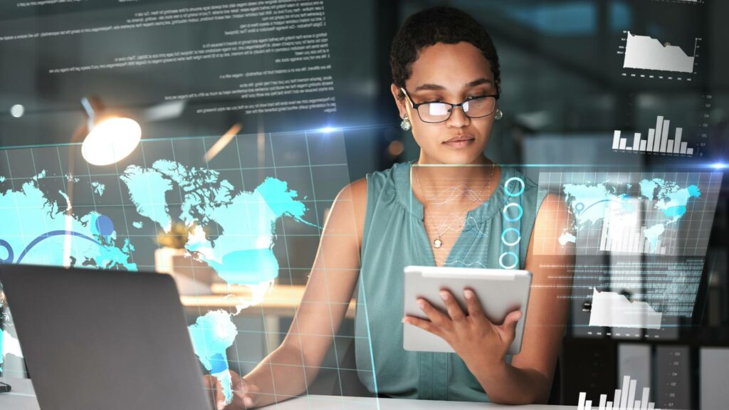 A woman wears glasses and works on a laptop, demonstrating her work on front end and back end systems development.