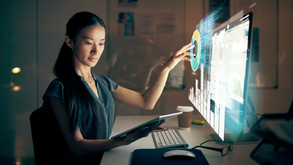 A woman sits on a desktop screen and works on software development.